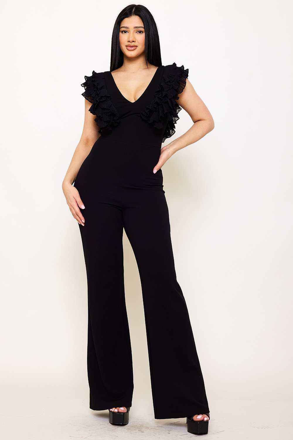 Black V-neck jumpsuit featuring ruffle sleeves and flared legs, perfect for a chic evening look from Boutinie.