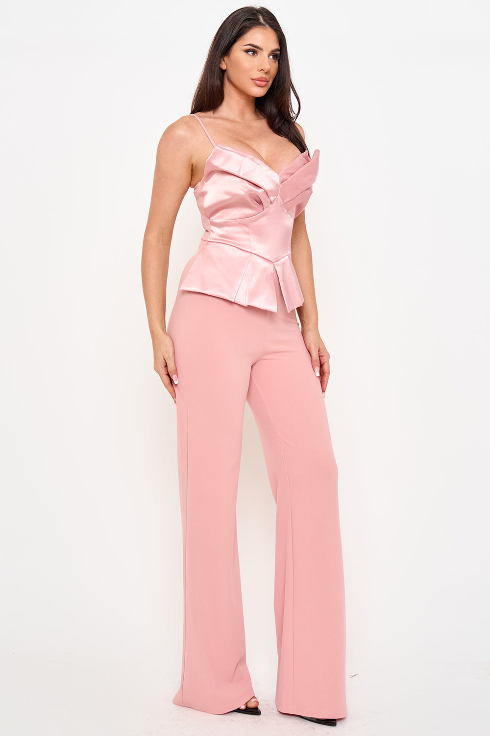 Model in pink satin peplum corset top and wide-leg trousers, perfect for a chic evening outfit from Boutinie.