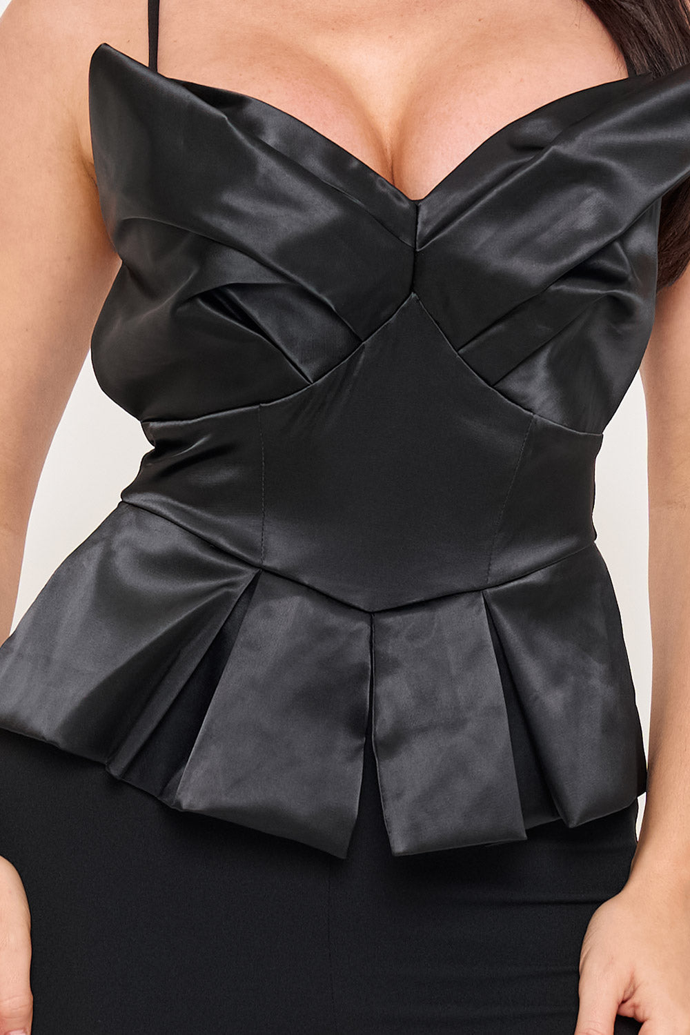 Black satin corset top with pleated peplum hem, sweetheart neckline, and spaghetti straps for a chic evening look.