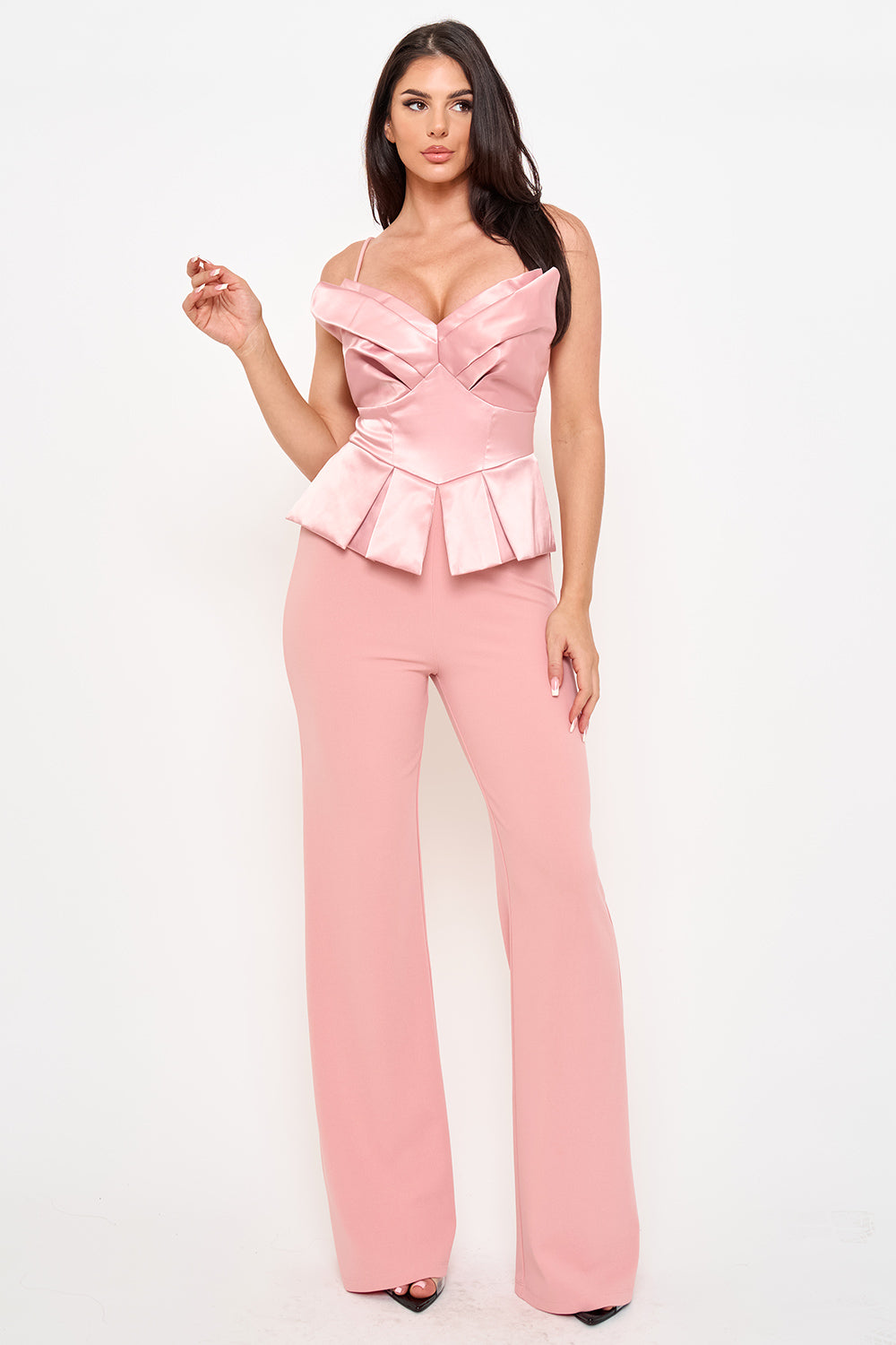 Model wears a pink satin peplum jumpsuit with a strapless sweetheart neckline and wide-leg trousers.