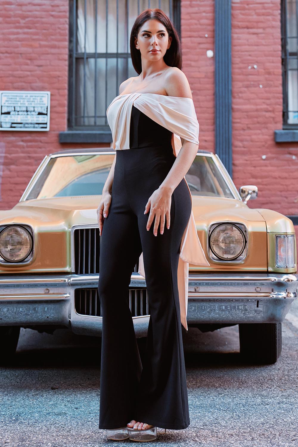 Model in a chic black and beige off-shoulder formal jumpsuit with wide-leg silhouette by Boutinie.