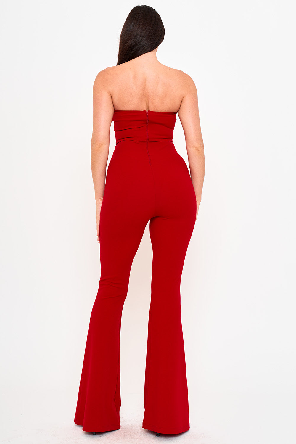 Back view of a strapless red jumpsuit with fitted bodice and flared trousers, perfect for an evening event.