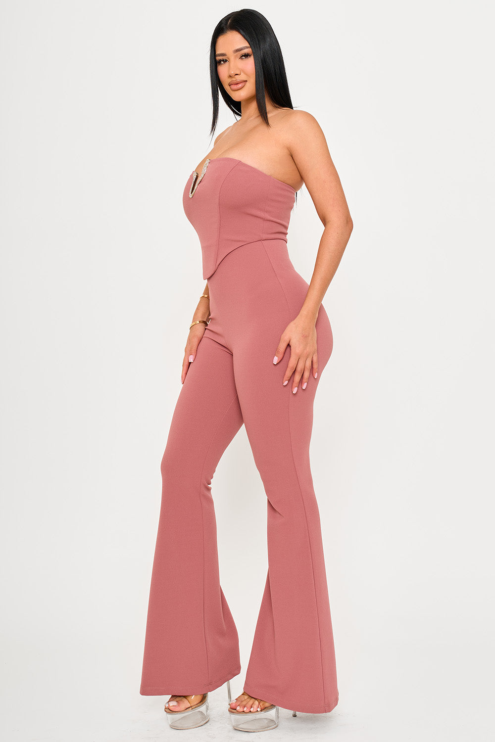 Mauve strapless corset jumpsuit with a V-neckline, form-fitting bodice, and flared legs for a chic evening look.