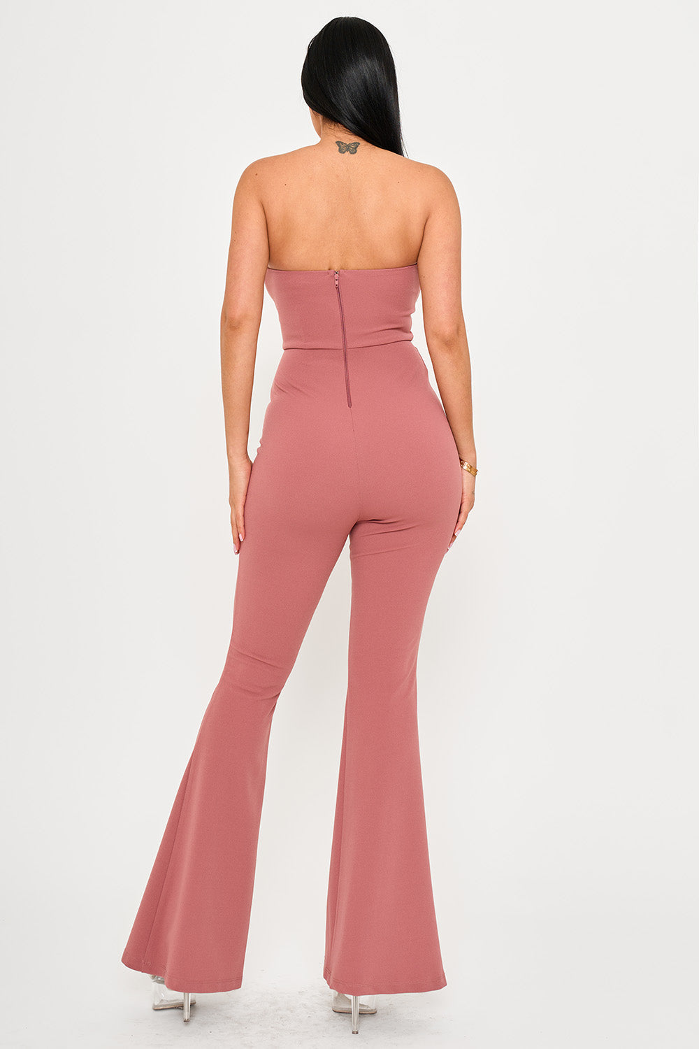 Back view of a mauve strapless jumpsuit with a fitted bodice and flared legs from Boutinie.