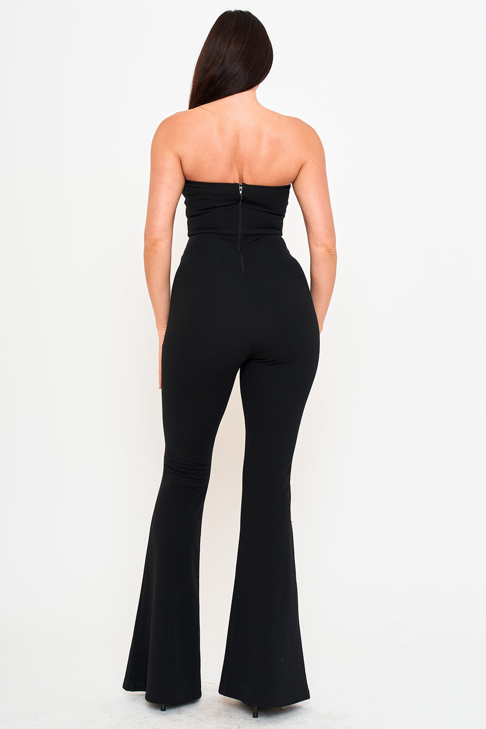 Back view of a black strapless flared jumpsuit with a fitted silhouette, perfect for a chic evening out.