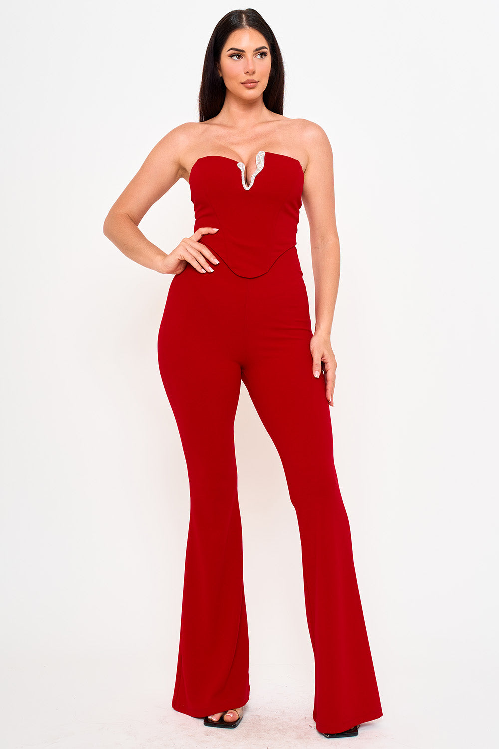 Red strapless jumpsuit with rhinestone V-neck detail and flared legs for a stylish evening look from Boutinie.