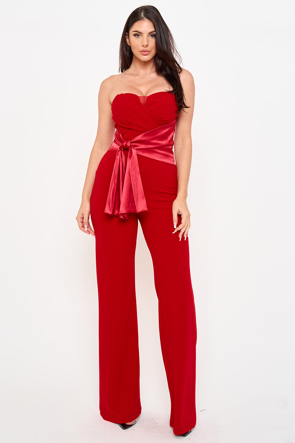 Red strapless wide-leg jumpsuit with a satin sash waist, perfect for formal evening wear at Boutinie.