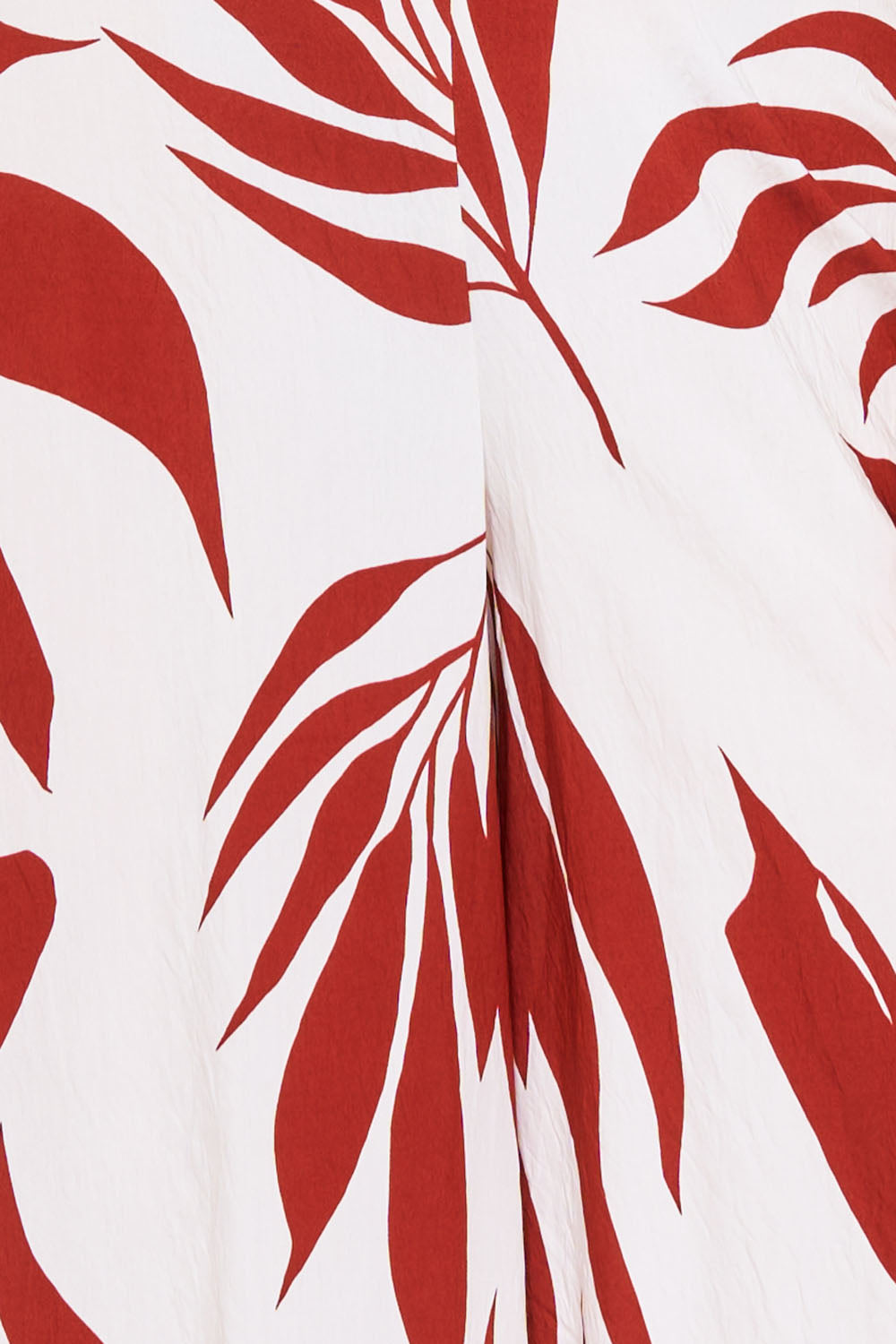 Boutinie white and rust red tropical palm leaf print fabric with a textured finish, ideal for summer vacation wear.
