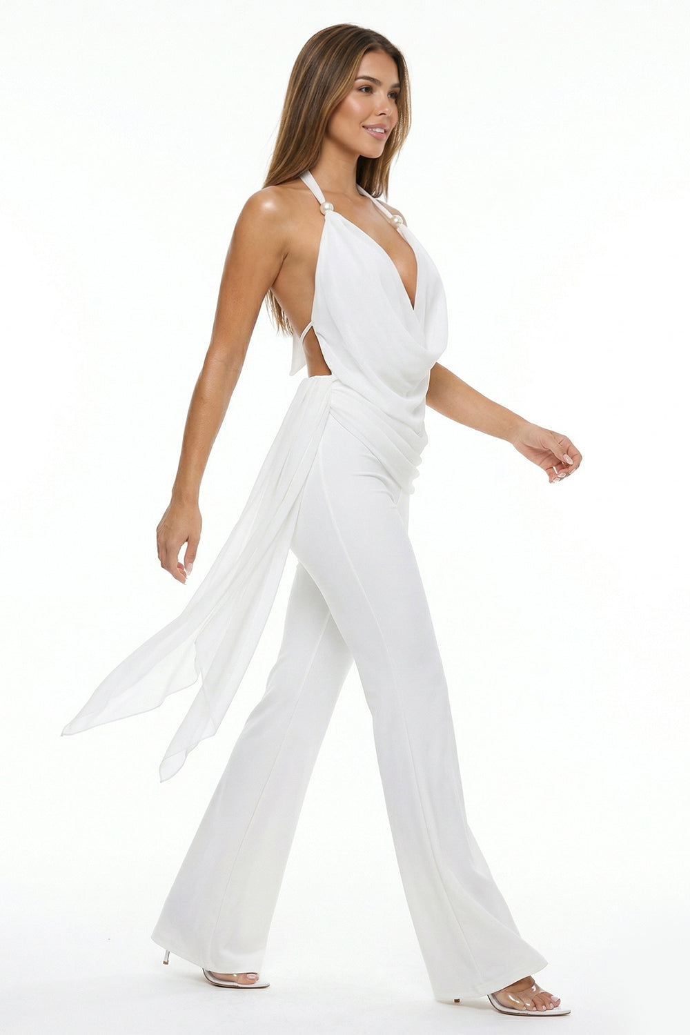 Elegant white halter-neck jumpsuit with pearl details, draped bodice, and flowing back train for evening events.