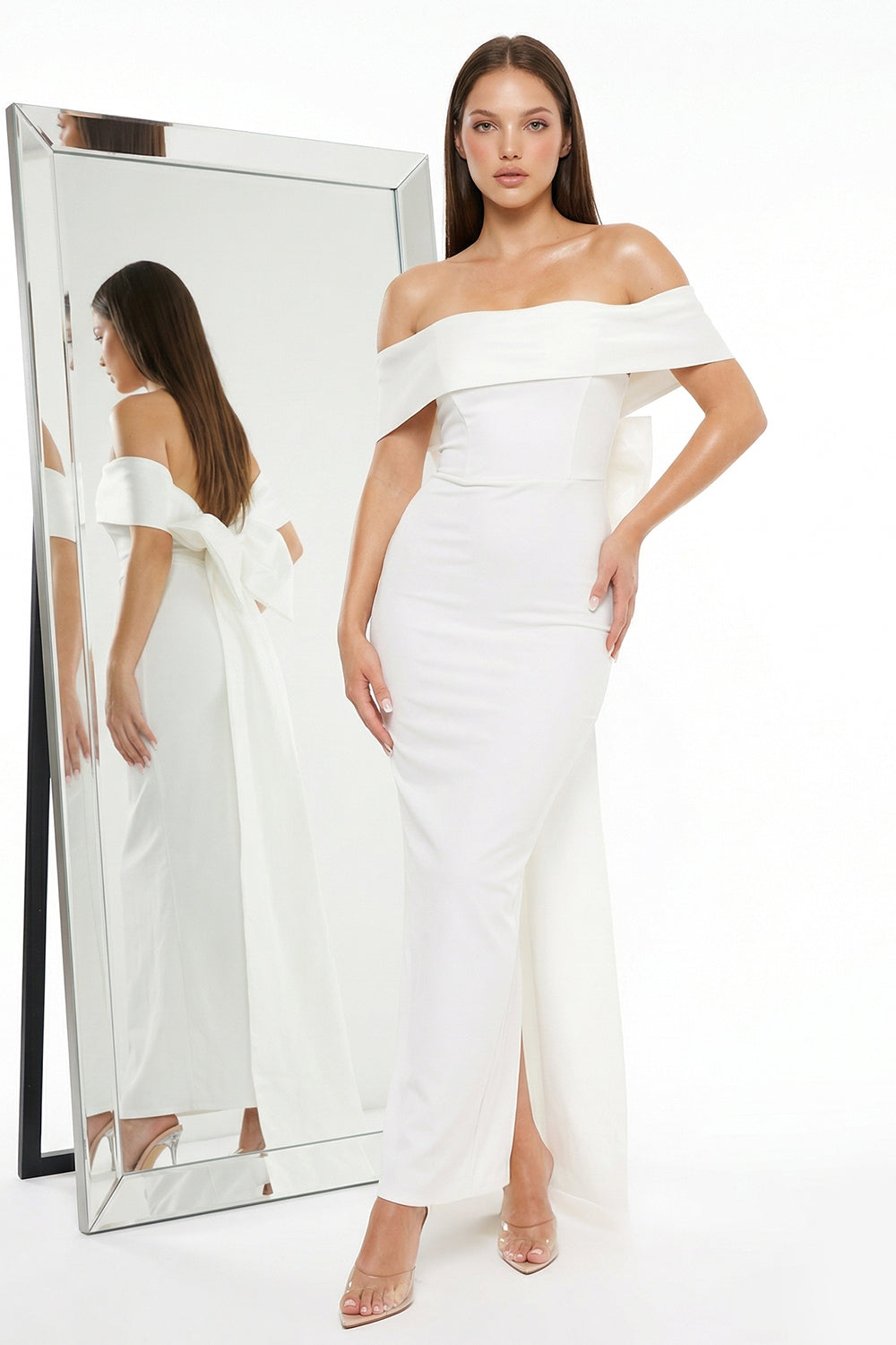 White off-the-shoulder evening gown by Boutinie featuring a fitted silhouette, floor-length skirt, and back bow detail.