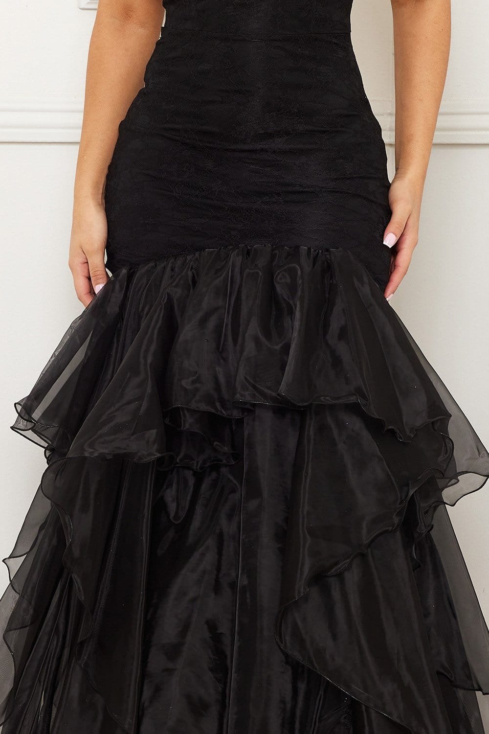 Black lace bodice mermaid evening gown with a voluminous tiered organza ruffle skirt for elegant formal occasions.