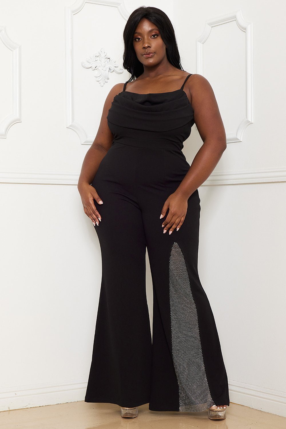Black sleeveless jumpsuit with cowl neckline, spaghetti straps, and rhinestone-detailed leg slit for formal events.
