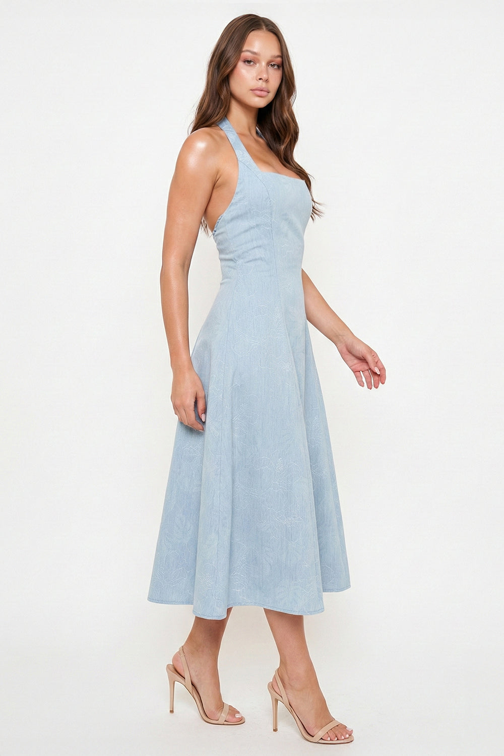 Light blue midi dress with a halter neckline, fitted bodice, and textured floral print for a chic daytime look.