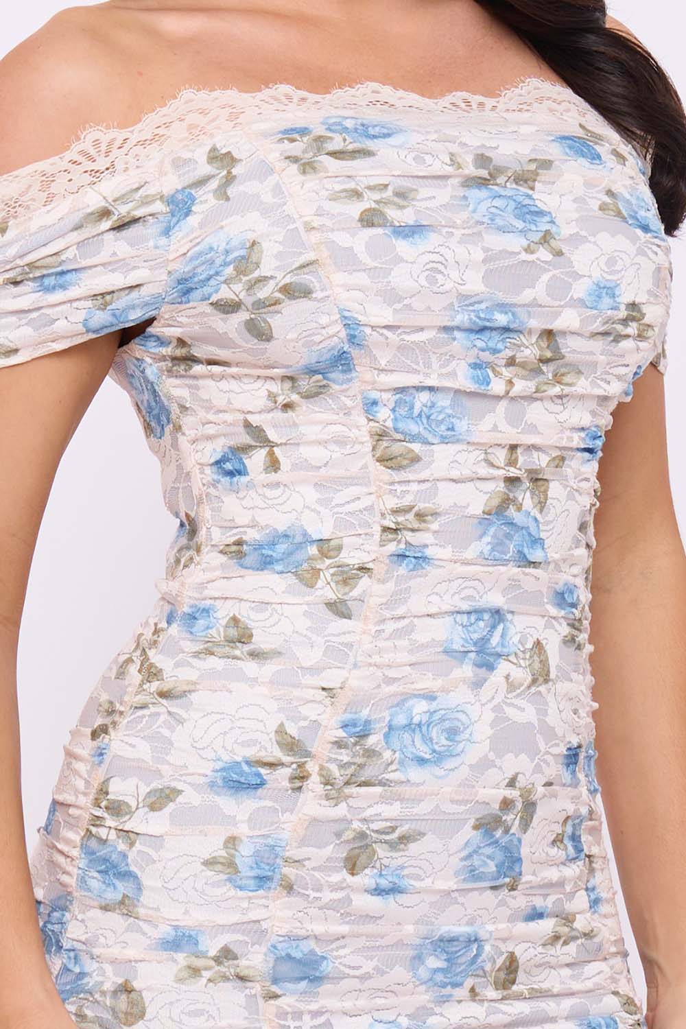 Off-shoulder ruched mini dress in cream floral lace with blue roses for romantic occasion wear. Boutinie fashion.