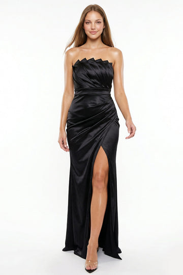 Boutinie black satin strapless evening gown with pleated bodice, draped waist, and high leg slit.