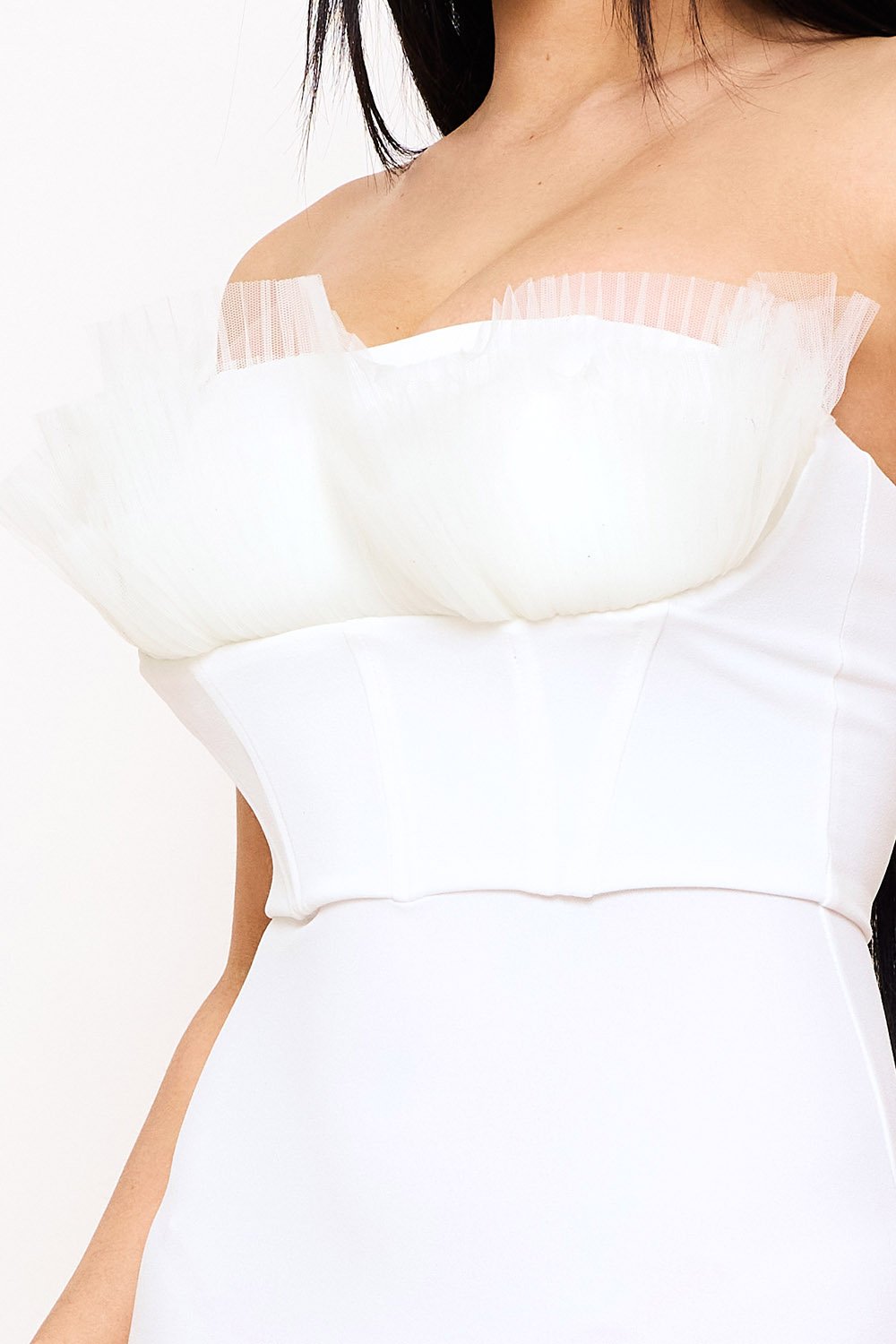 White strapless corset top with sheer tulle trim detailing, perfect for a chic party look at Boutinie.