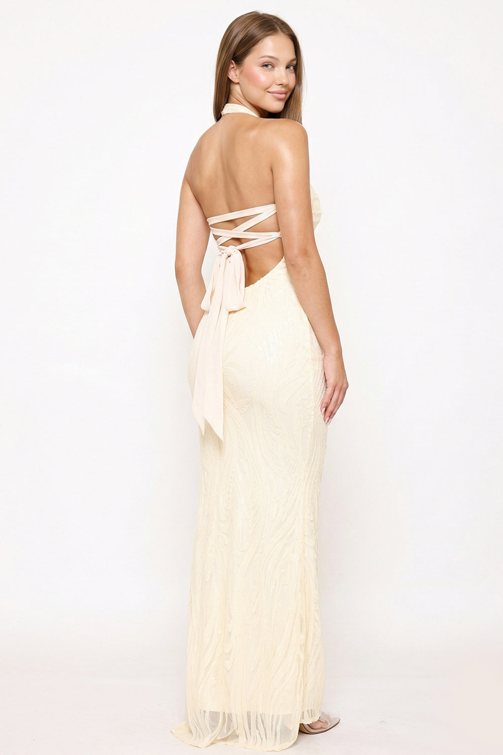 Cream sequined floor-length formal gown with a backless halter neckline and tie-up detail from Boutinie.