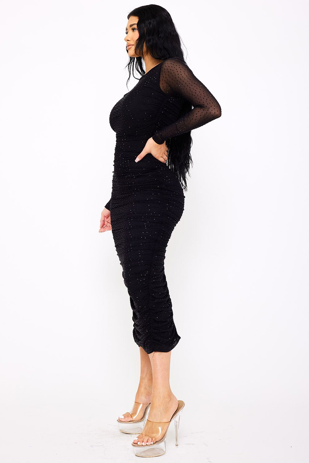Black midi dress with long sleeves, ruching, and subtle sparkle, perfect for evening wear from Boutinie.