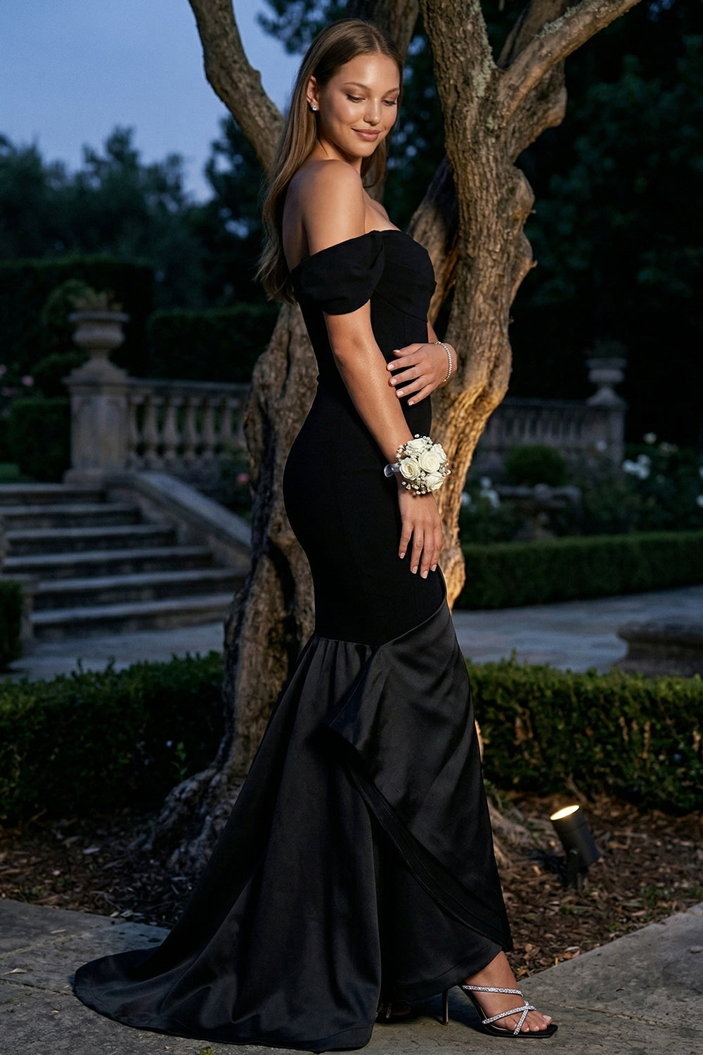 Elegant black off-the-shoulder mermaid prom dress with satin hem detail, perfect for formal evening occasions.