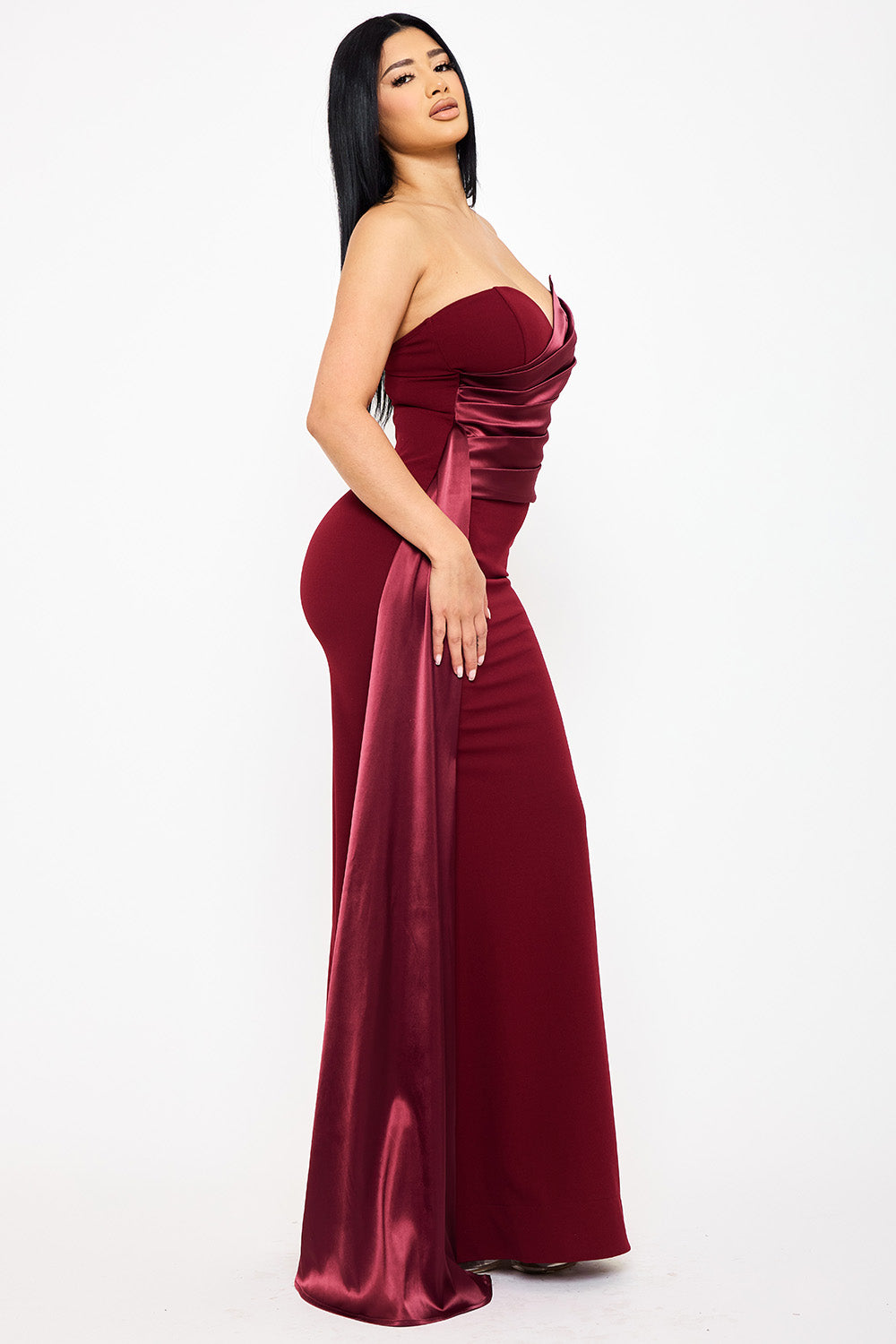 Burgundy strapless mermaid evening gown with satin ruched detailing for a formal event at Boutinie.