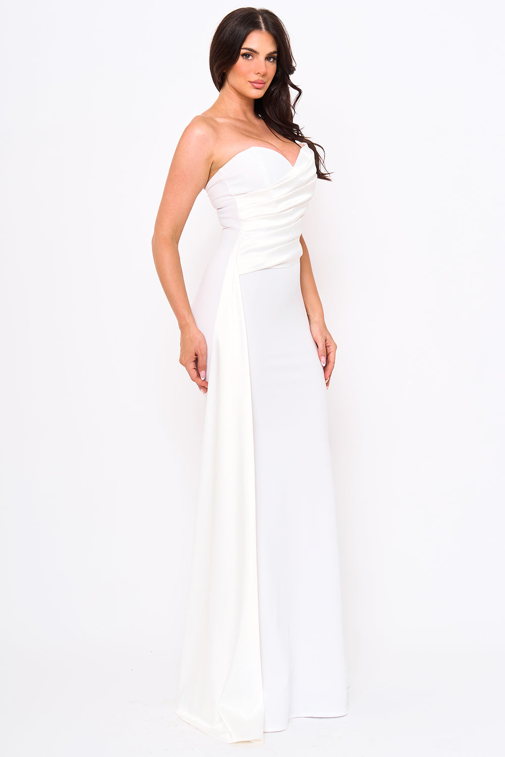 Model wearing a white strapless floor-length evening gown with draped bodice detailing from Boutinie.