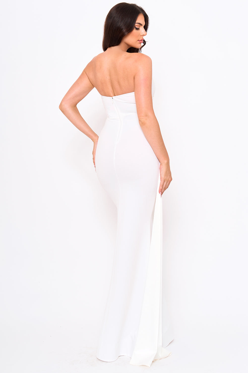 White strapless maxi evening gown with a form-fitting silhouette and side train detail from Boutinie.