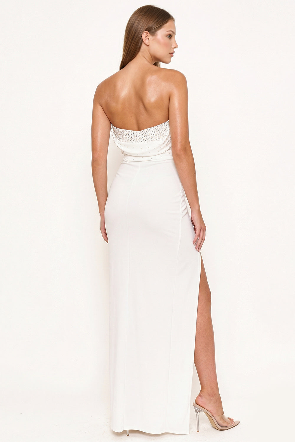 White strapless maxi dress with crystal embellishments and side slit, perfect for an elegant formal evening.
