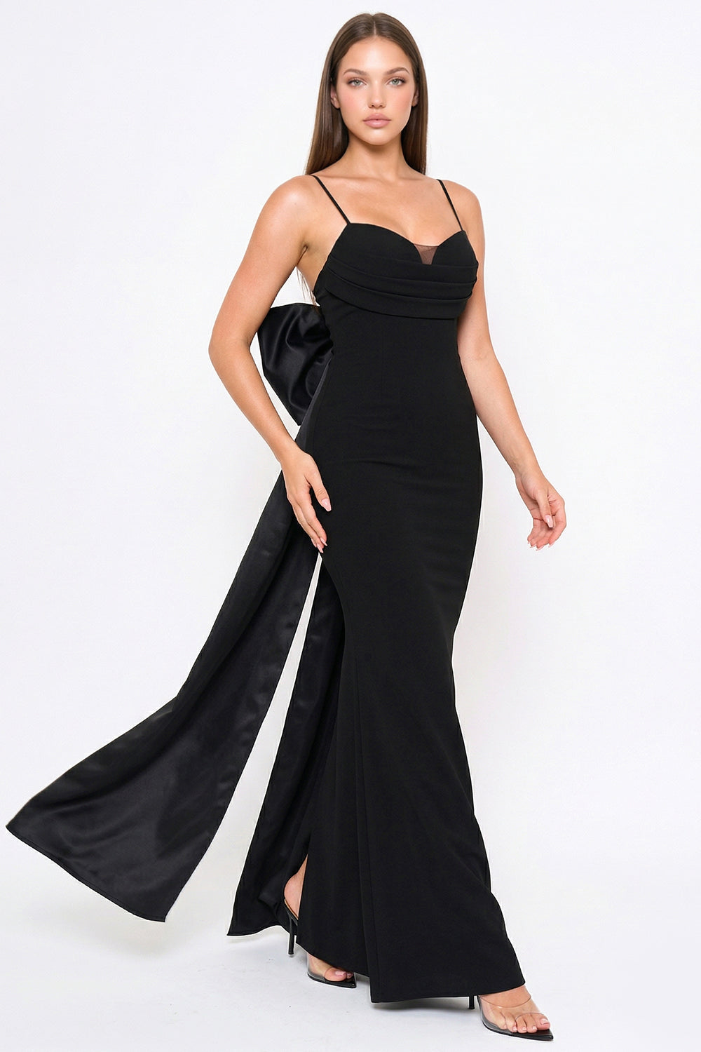 Black floor-length evening gown with a sweetheart neckline, spaghetti straps, and a dramatic back bow by Boutinie.