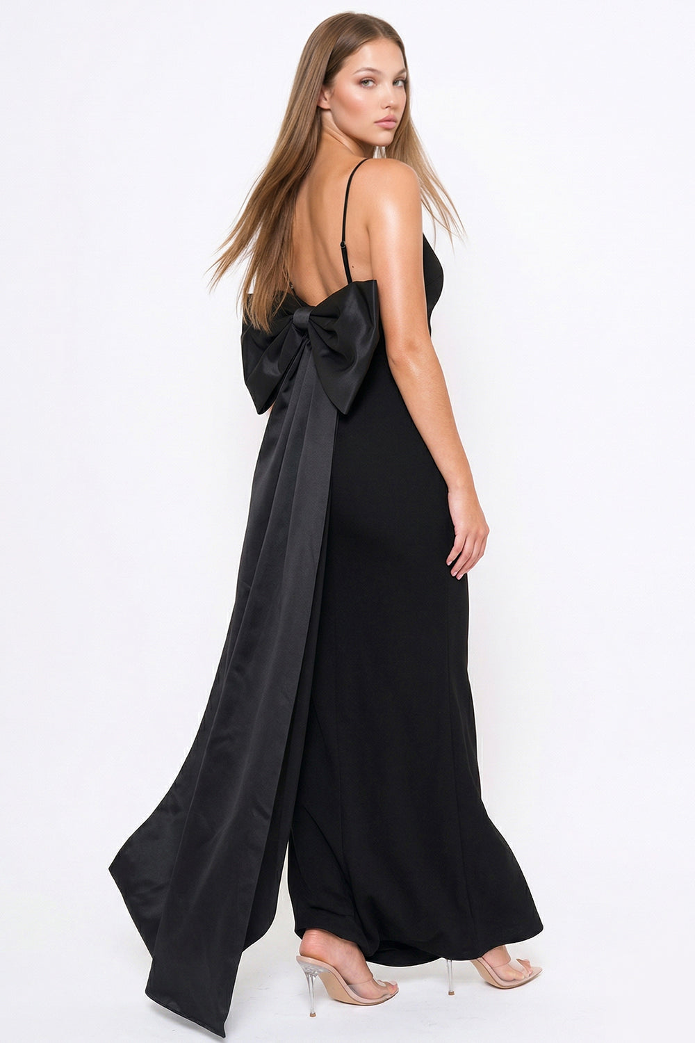 Elegant black evening gown with spaghetti straps and a dramatic satin bow back detail by Boutinie.