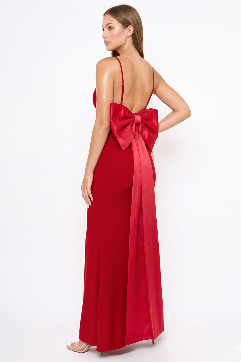 Red evening gown with spaghetti straps and a large back bow detail by Boutinie. Elegant formal floor-length dress.