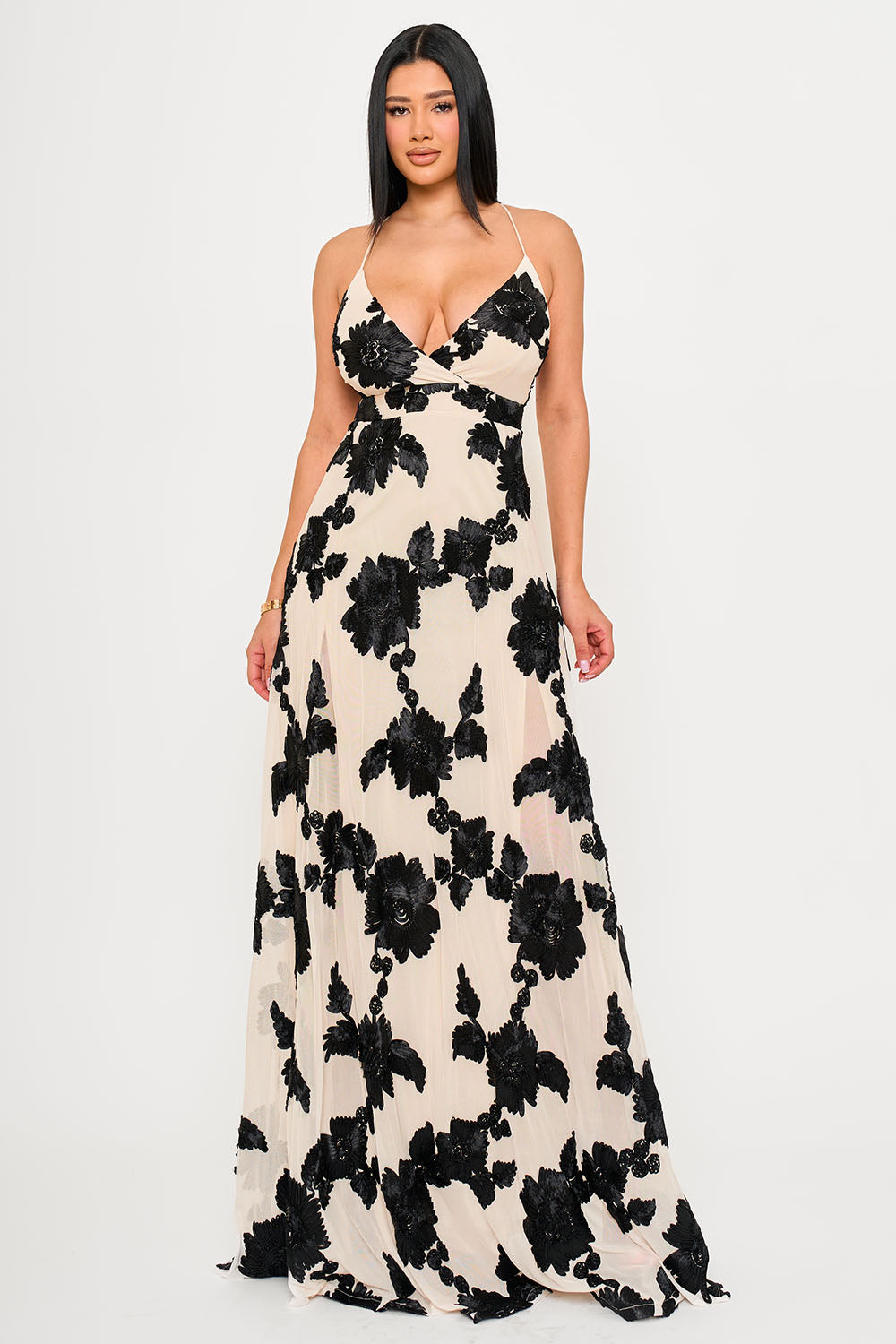 Boutinie beige maxi dress with black floral embroidery, V-neckline, spaghetti straps, and elegant evening silhouette.