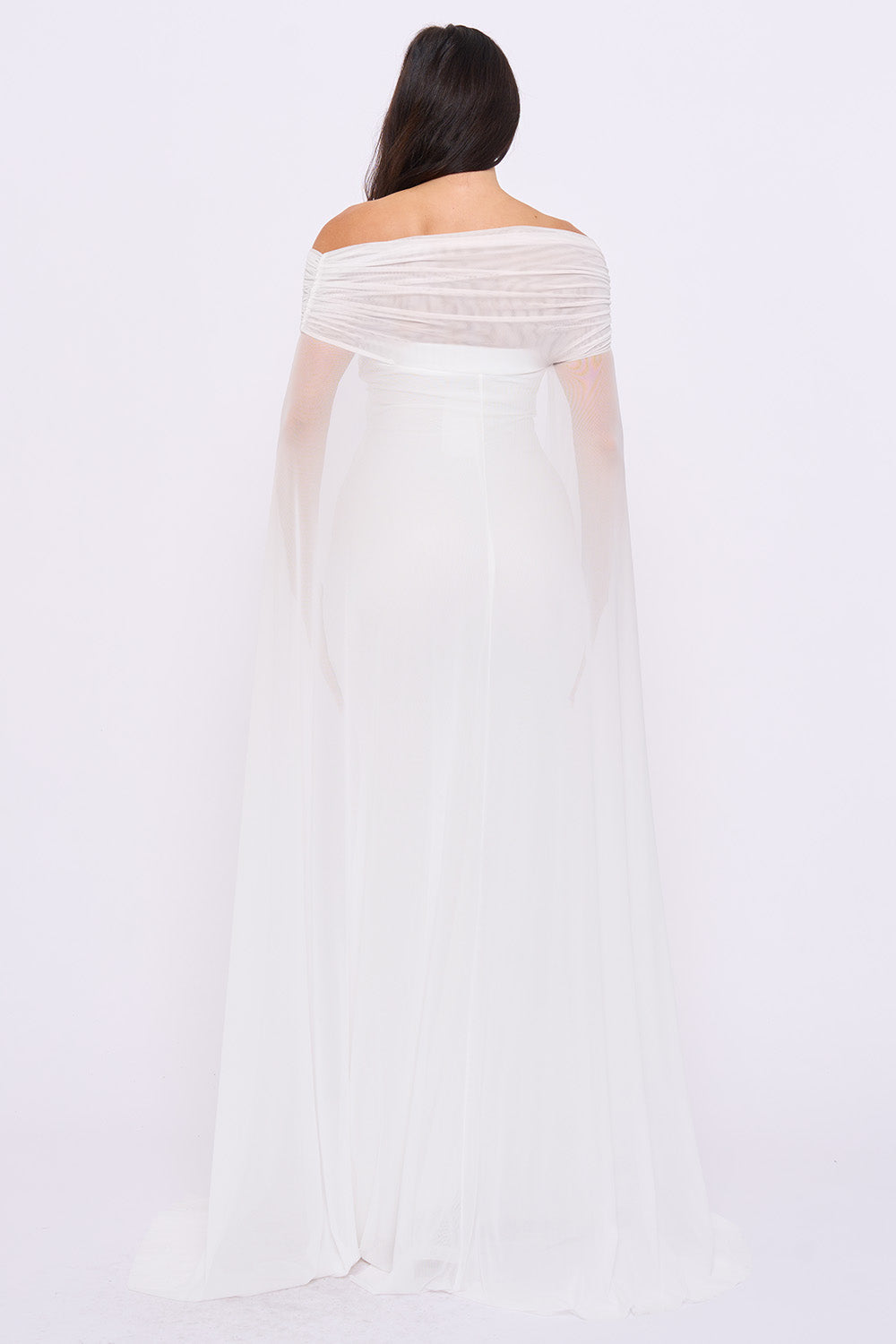 Back view of a white off-shoulder bridal gown with a ruched bodice and long, flowing sheer mesh cape sleeves.