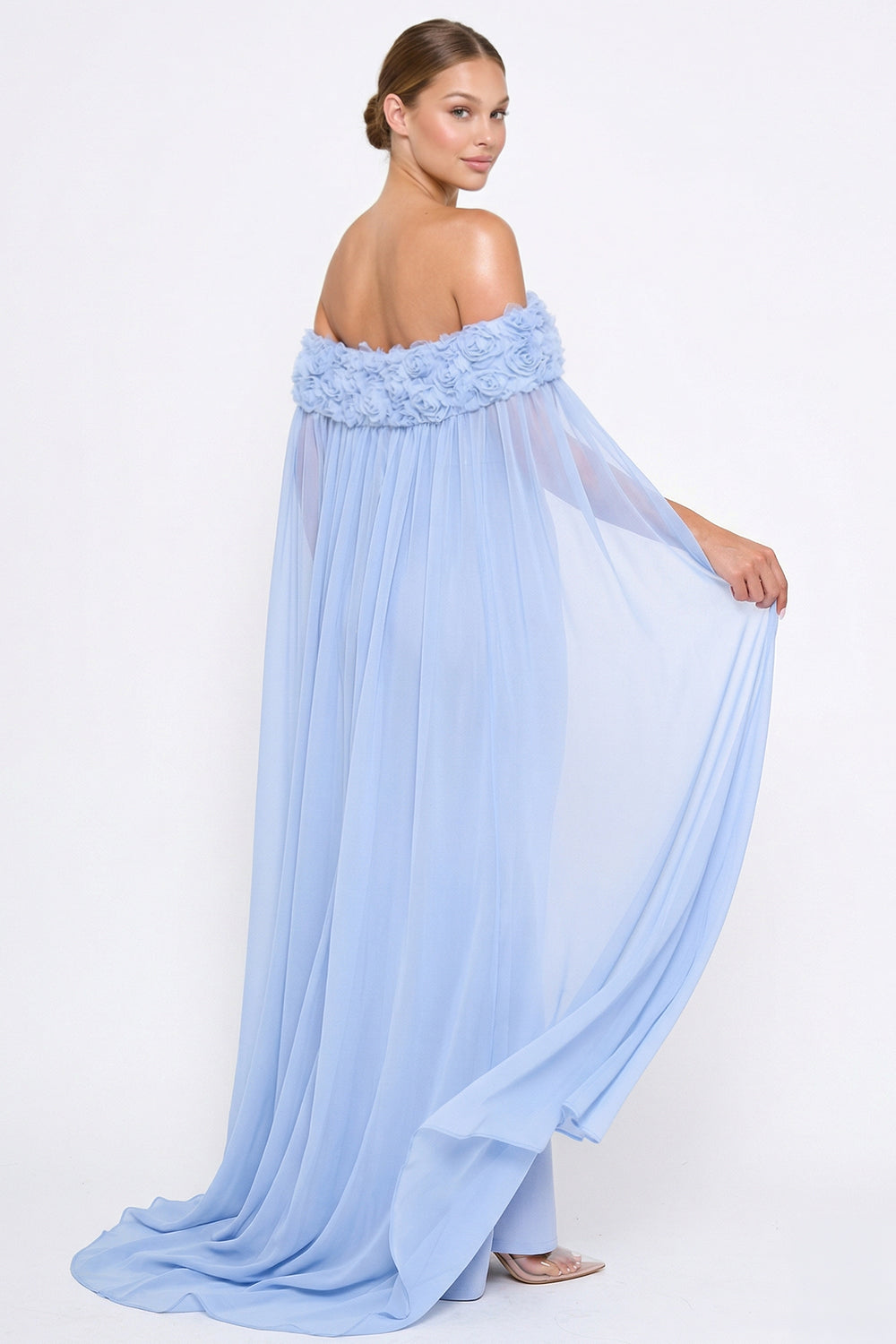 Light blue off-the-shoulder gown with floral neckline and sheer flowing cape for formal events by Boutinie.