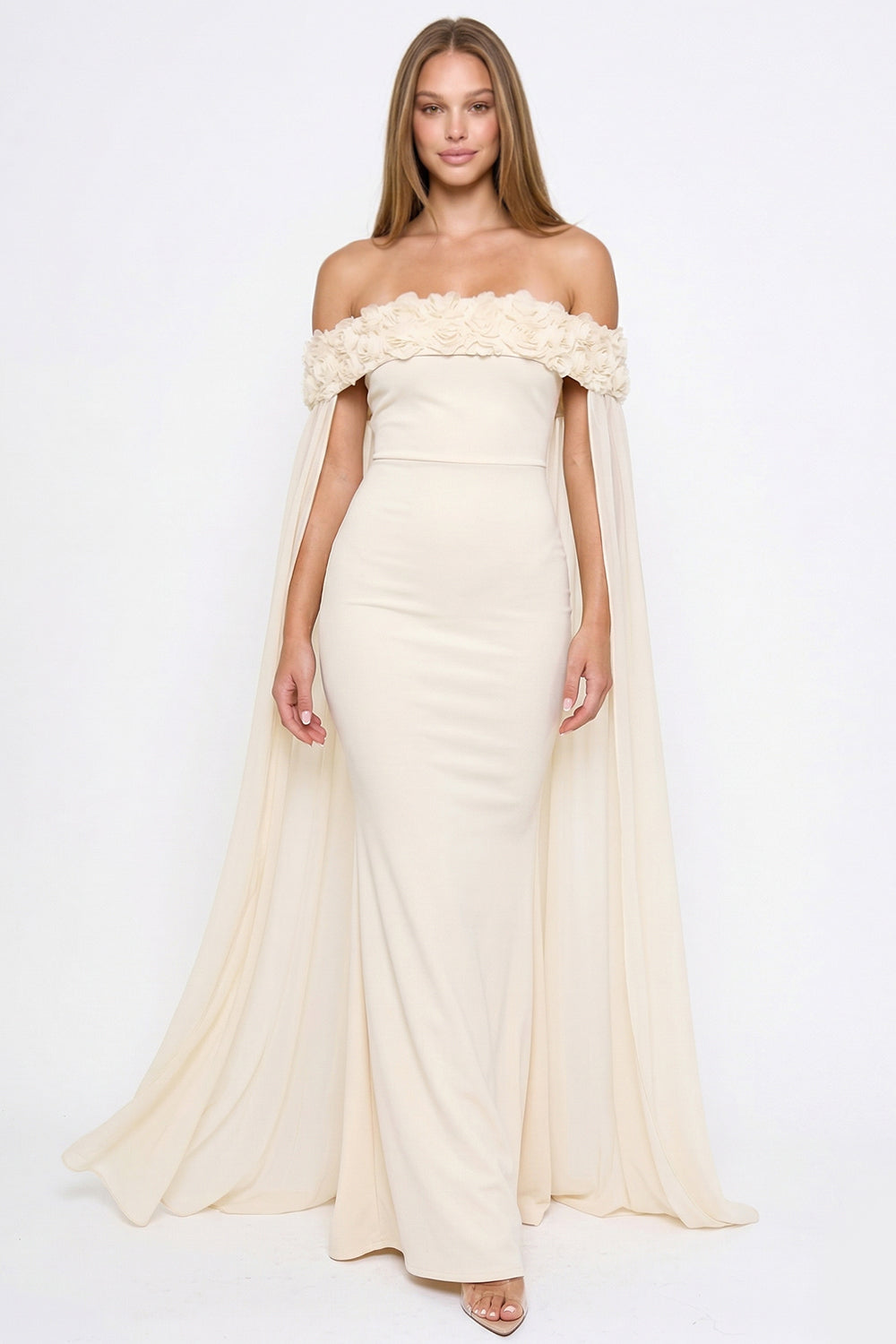 Cream off-the-shoulder evening gown with floral neckline detail and flowing cape sleeves by Boutinie.
