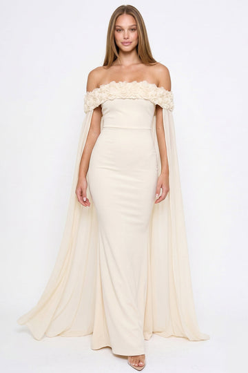 Cream off-the-shoulder evening gown with floral neckline detail and flowing cape sleeves by Boutinie.