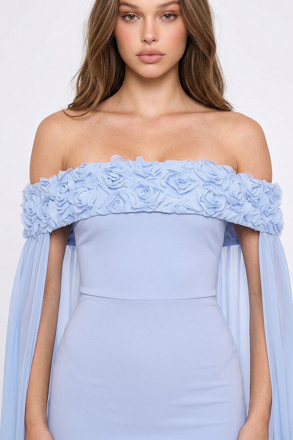 Light blue off-the-shoulder formal gown with 3D floral neckline and flowing chiffon sleeves by Boutinie.