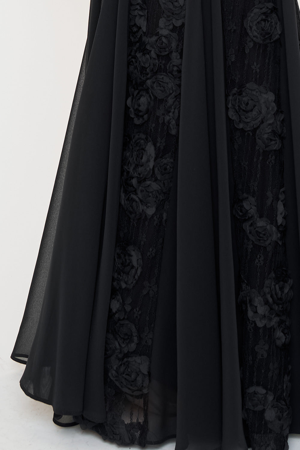 Boutinie black evening gown featuring a flowing chiffon skirt with intricate floral lace appliqué details.