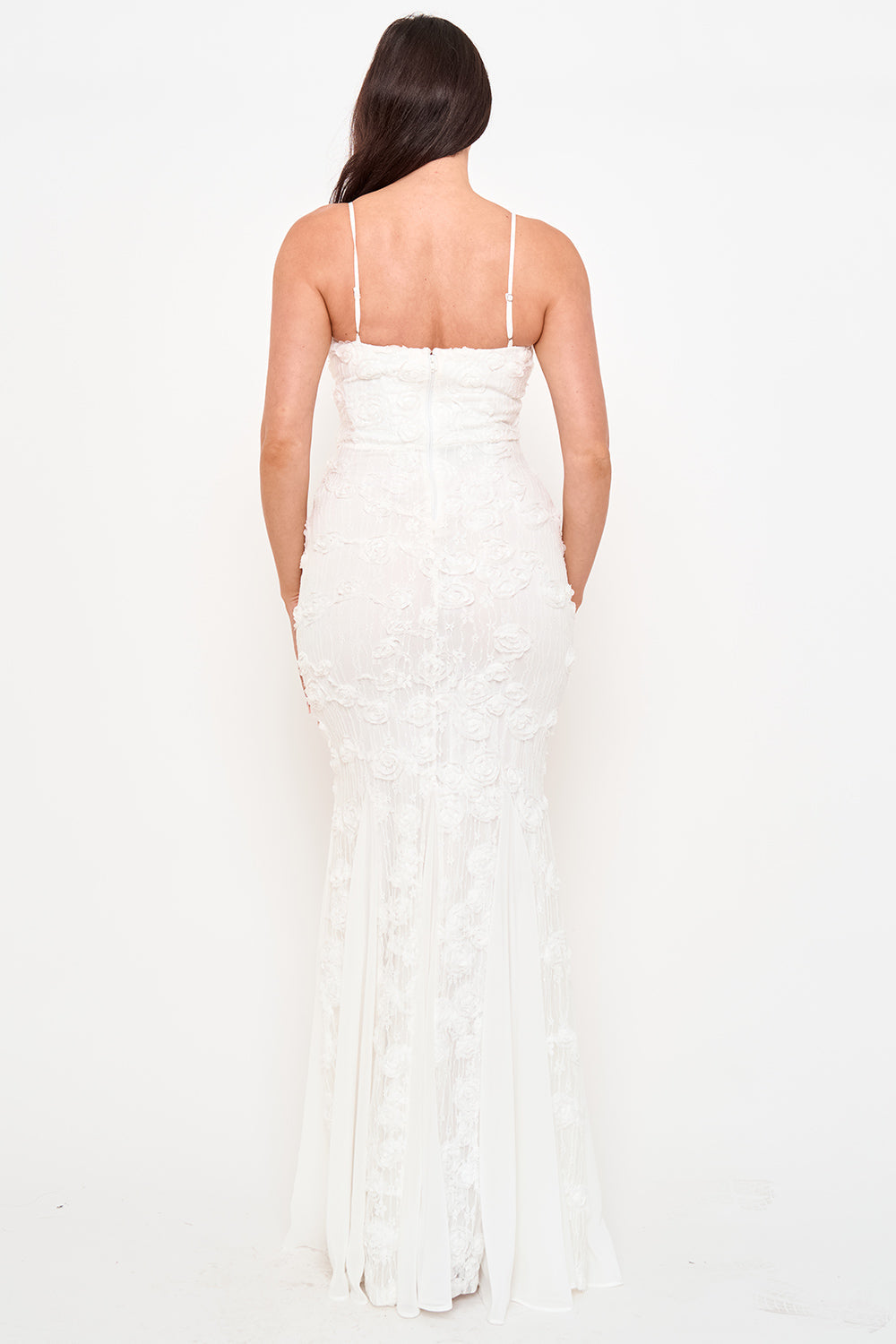 Back view of a white floor-length bridal gown with spaghetti straps, floral lace texture, and mermaid silhouette.