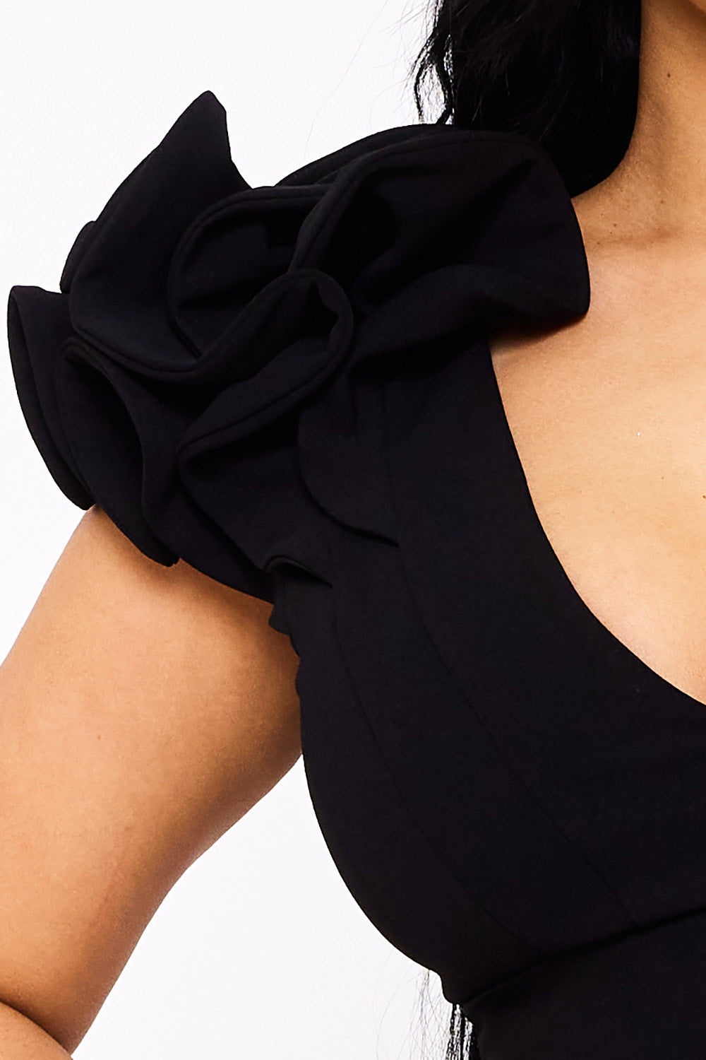 Black cocktail dress with a plunging neckline and dramatic ruffle shoulder detail for an elegant evening look.