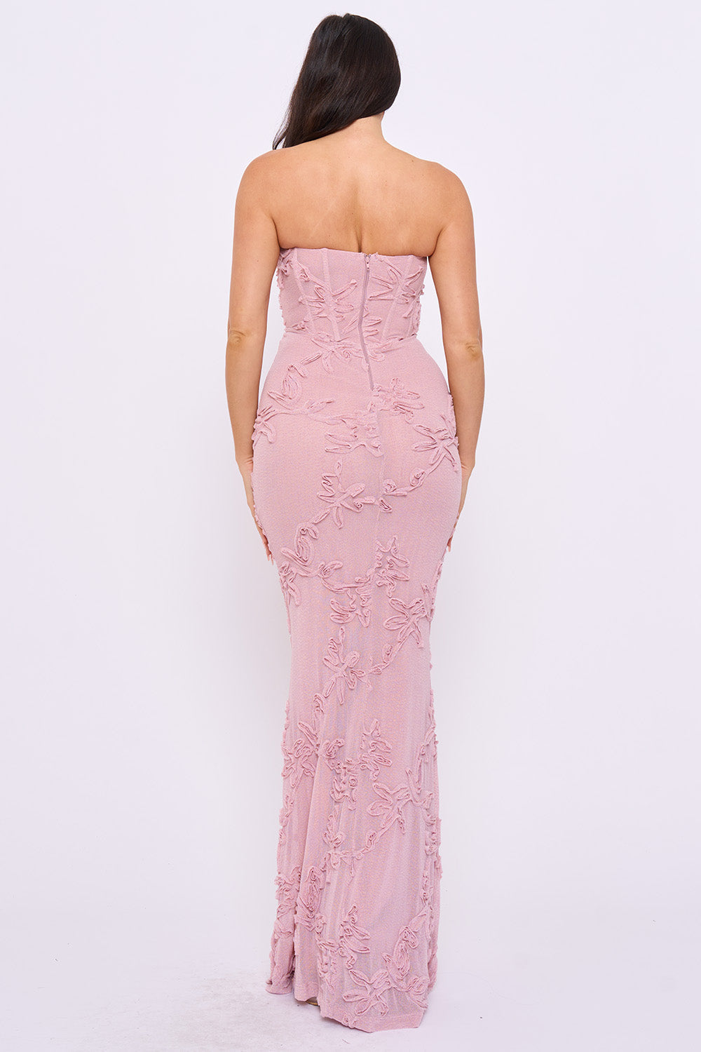Back view of a mauve strapless maxi evening gown with floral textured fabric and a corset-style bodice from Boutinie.