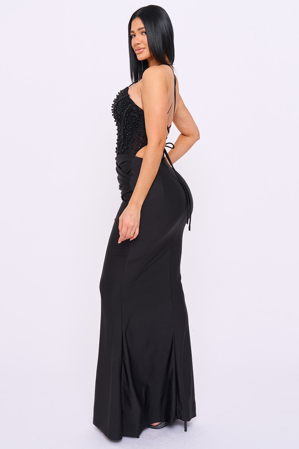 Black maxi evening dress featuring a beaded bodice, lace-up back, and fitted silhouette from Boutinie.