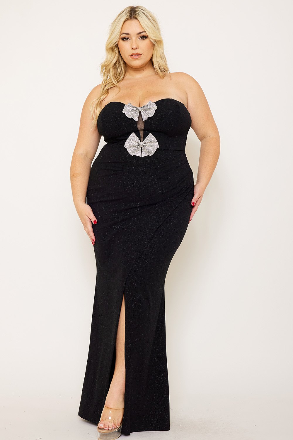 Black strapless evening gown with glitter fabric, sparkling bow details, and side slit for a formal event.